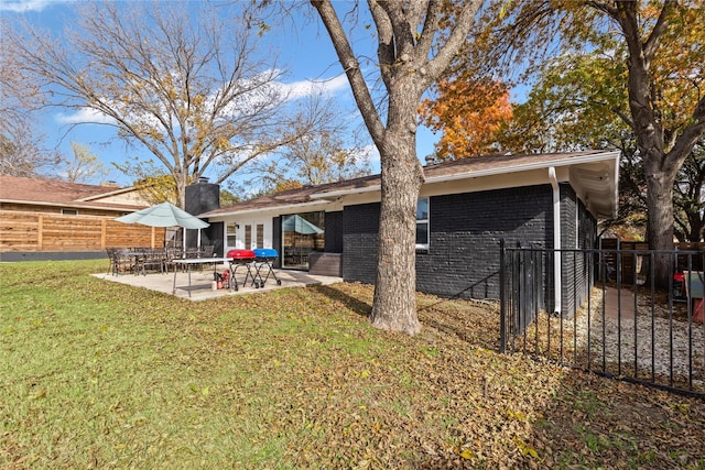 back of property featuring a patio area and a lawn