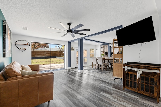 living room featuring hardwood / wood-style flooring, ceiling fan, and a textured ceiling