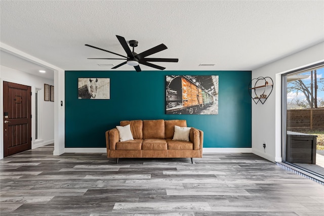 unfurnished room featuring hardwood / wood-style floors, ceiling fan, and a textured ceiling