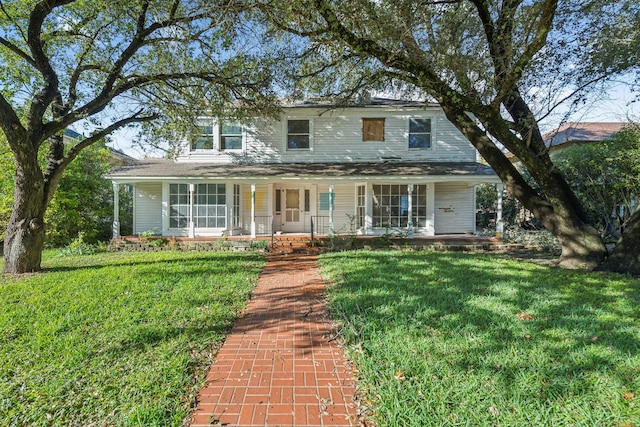 view of front of house featuring covered porch and a front yard