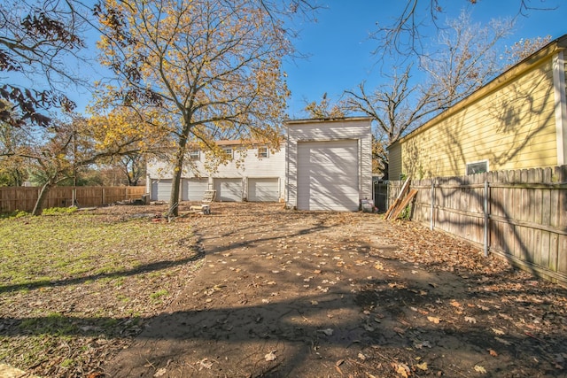 view of yard featuring a garage and an outbuilding