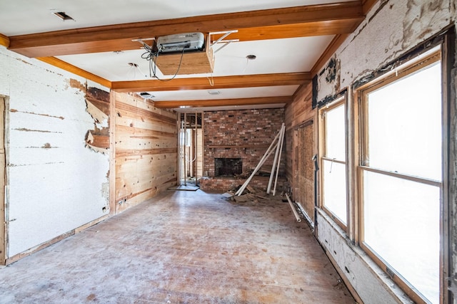 unfurnished room featuring a fireplace and beamed ceiling