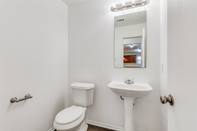 bathroom featuring toilet, baseboards, and visible vents