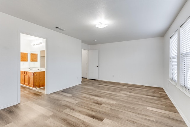 empty room with light hardwood / wood-style flooring and plenty of natural light