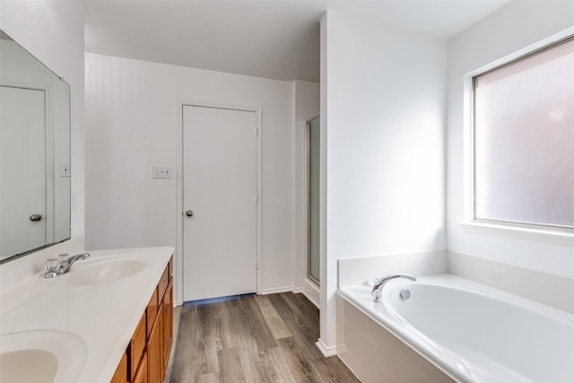 full bathroom with wood finished floors, a sink, a bath, and a shower stall