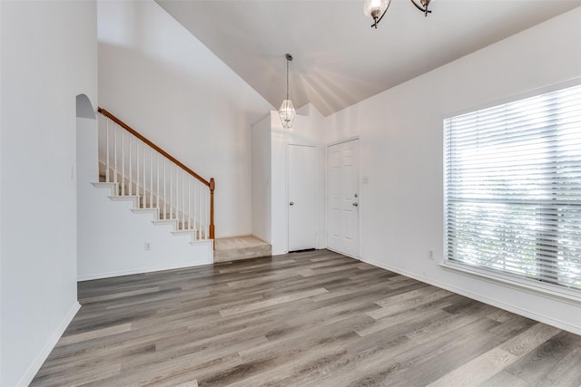 foyer entrance featuring hardwood / wood-style floors, an inviting chandelier, and plenty of natural light