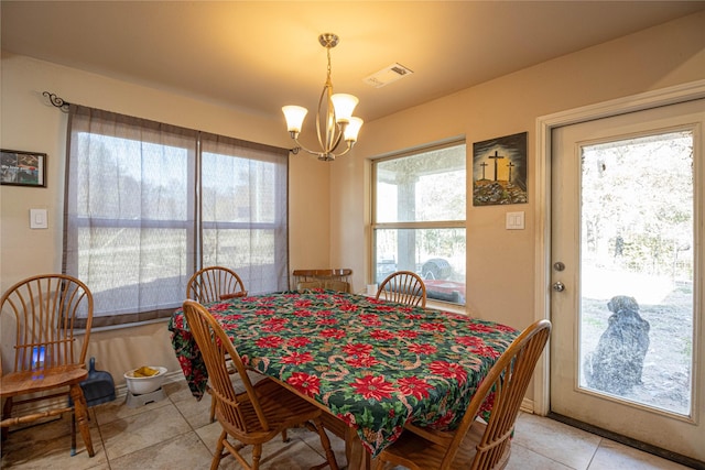 dining room featuring a healthy amount of sunlight, light tile patterned floors, and a chandelier