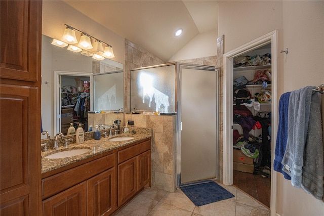 bathroom featuring tile patterned flooring, vanity, lofted ceiling, and a shower with door