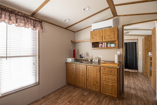 kitchen featuring a textured ceiling, dark hardwood / wood-style flooring, a wall unit AC, and sink