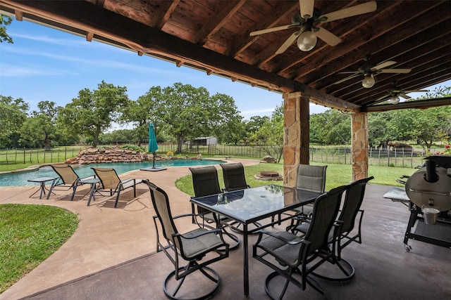 view of patio featuring a fenced in pool, ceiling fan, and a grill