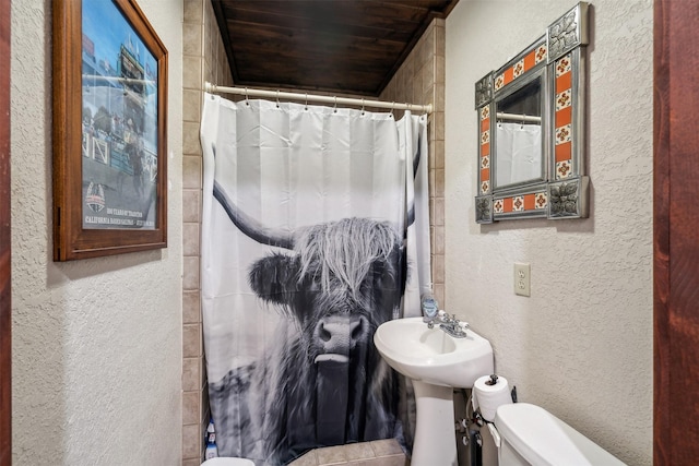 bathroom with a shower with shower curtain, toilet, and wooden ceiling