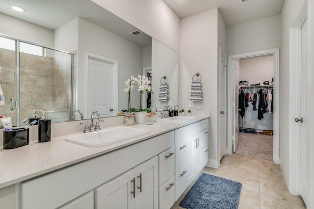 bathroom featuring tile patterned flooring, vanity, and a shower with door