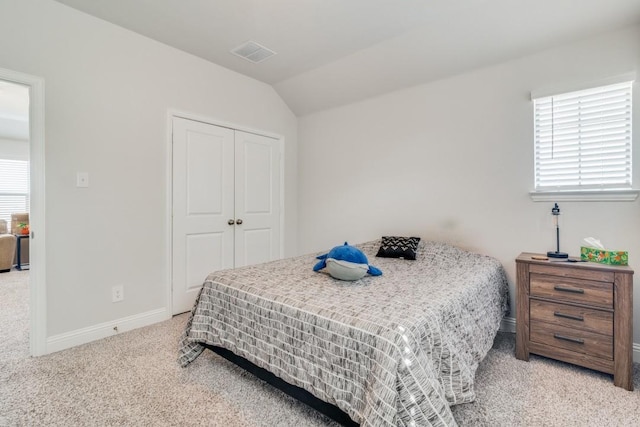 bedroom featuring carpet floors, a closet, and lofted ceiling