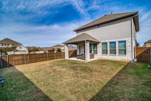 rear view of property with a yard and a patio