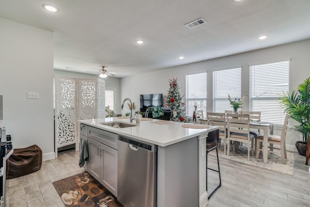 kitchen with a center island with sink, dishwasher, sink, and a wealth of natural light