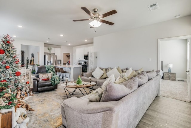 living room with ceiling fan and light hardwood / wood-style floors