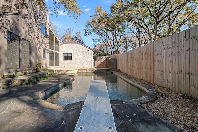 view of swimming pool featuring a diving board