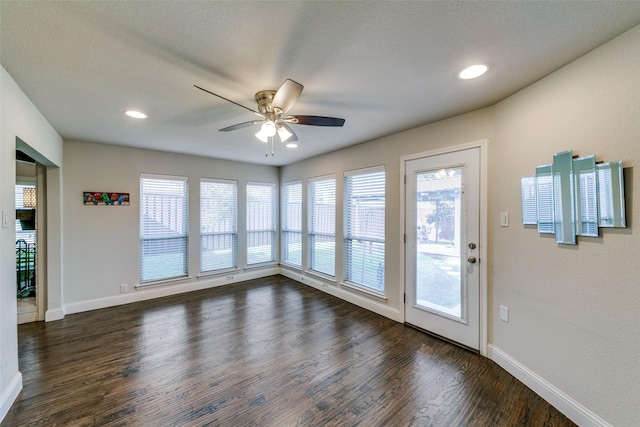 interior space featuring ceiling fan, dark wood-type flooring, and a textured ceiling