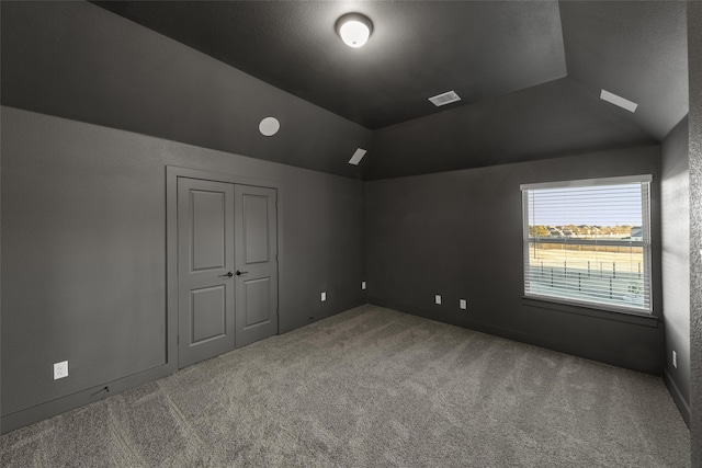 unfurnished room featuring vaulted ceiling and carpet