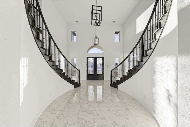 foyer with stairway, baseboards, a high ceiling, french doors, and marble finish floor