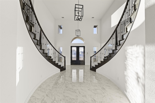 entrance foyer featuring french doors and a high ceiling