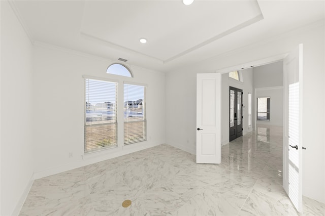 empty room with french doors, ornamental molding, a healthy amount of sunlight, and a tray ceiling