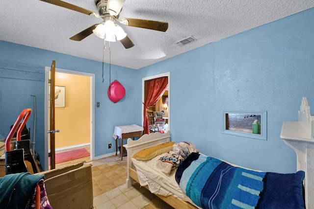 tiled bedroom with a textured ceiling and ceiling fan