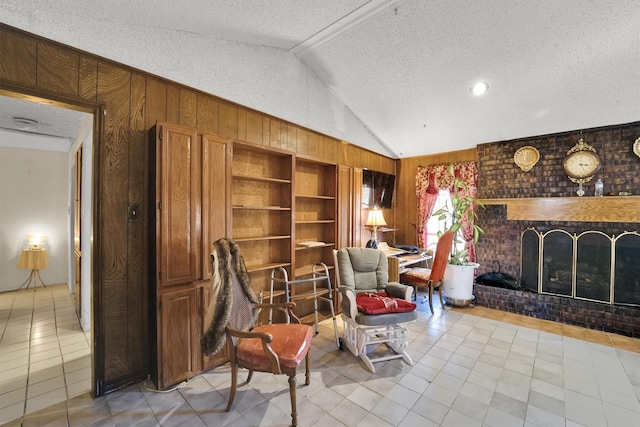 living area featuring wood walls, a fireplace, light tile patterned flooring, and lofted ceiling