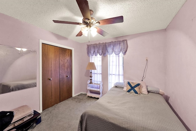 carpeted bedroom featuring ceiling fan, a textured ceiling, and a closet