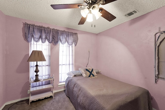 bedroom featuring ceiling fan, carpet floors, and a textured ceiling