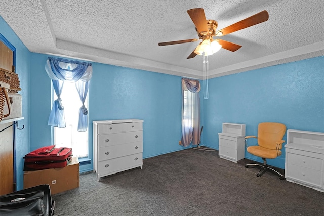 interior space featuring a textured ceiling, a tray ceiling, and ceiling fan