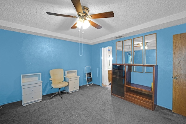 unfurnished room with dark colored carpet, ceiling fan, and a textured ceiling