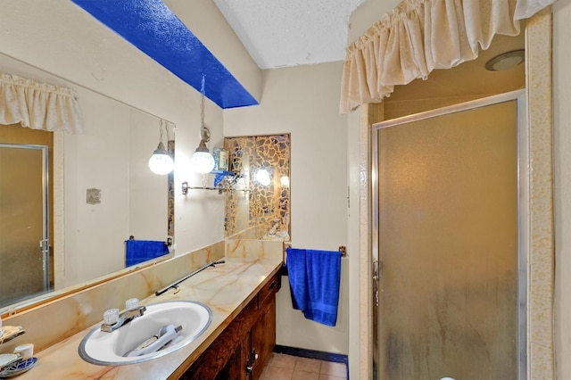 bathroom with tile patterned flooring, a textured ceiling, vanity, and a shower with door