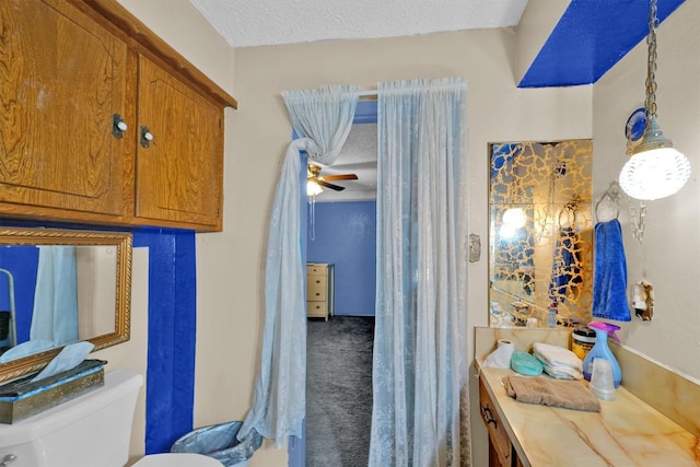 bathroom featuring a textured ceiling, toilet, and ceiling fan