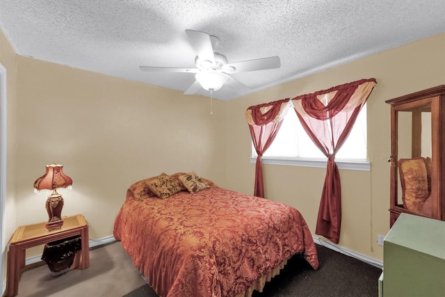 bedroom with ceiling fan, carpet floors, and a textured ceiling