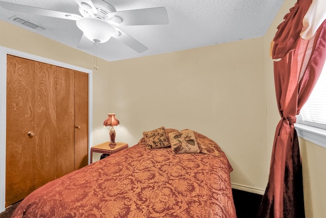 bedroom with a textured ceiling, a closet, and ceiling fan