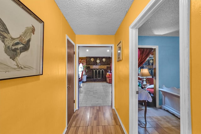 hallway featuring wood-type flooring and a textured ceiling