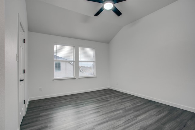 spare room featuring lofted ceiling, baseboards, dark wood finished floors, and a ceiling fan