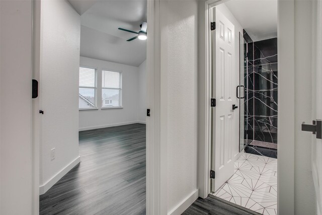 corridor featuring dark wood-style flooring and baseboards