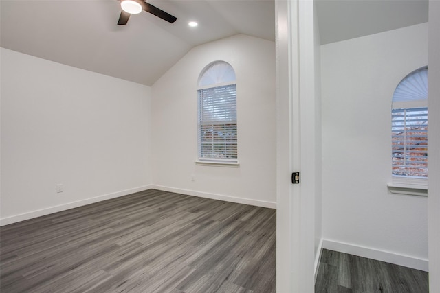 spare room with dark wood finished floors, vaulted ceiling, baseboards, and ceiling fan