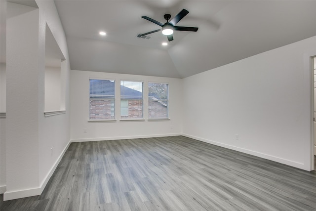 unfurnished room featuring baseboards, visible vents, a ceiling fan, lofted ceiling, and wood finished floors