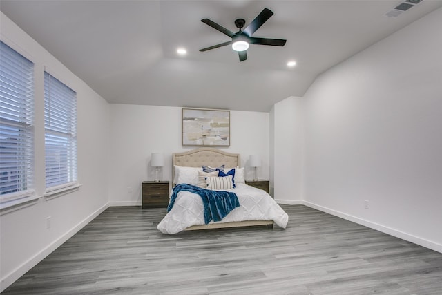 bedroom featuring lofted ceiling, visible vents, ceiling fan, wood finished floors, and baseboards