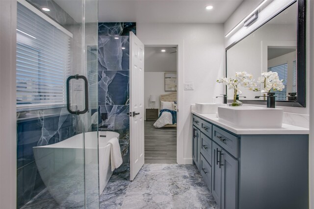 bathroom featuring a freestanding bath, connected bathroom, and vanity