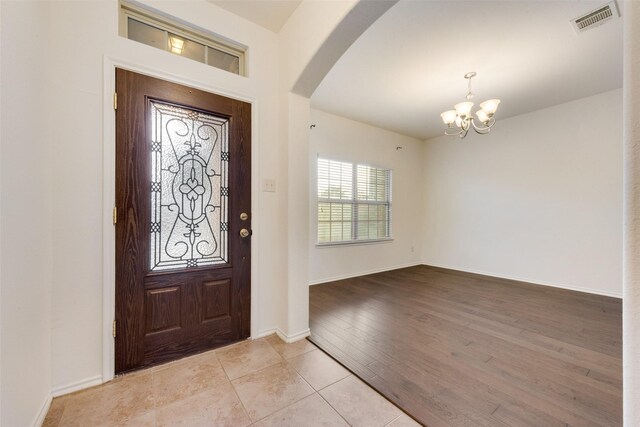 entrance foyer featuring an inviting chandelier and light hardwood / wood-style flooring