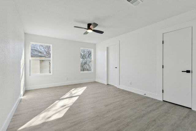 unfurnished bedroom featuring light wood-style flooring, visible vents, baseboards, and ceiling fan