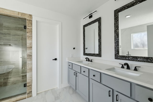 bathroom with marble finish floor, double vanity, a sink, and a shower stall