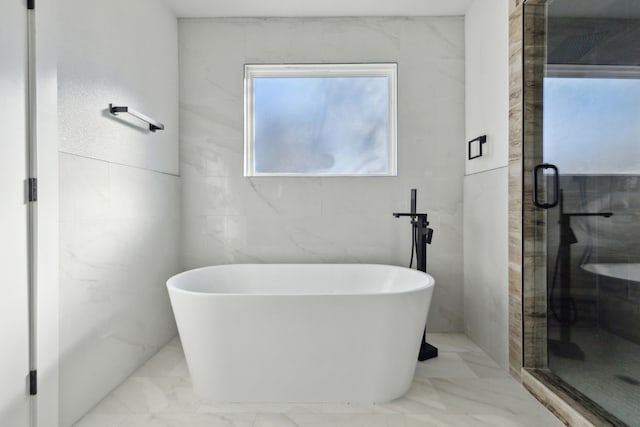 full bathroom with a stall shower, marble finish floor, and a freestanding bath