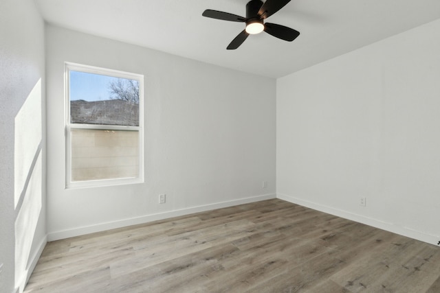 spare room with a ceiling fan, light wood-style flooring, and baseboards