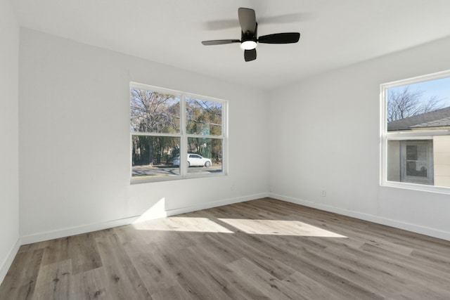 unfurnished room with a ceiling fan, light wood-style flooring, and baseboards