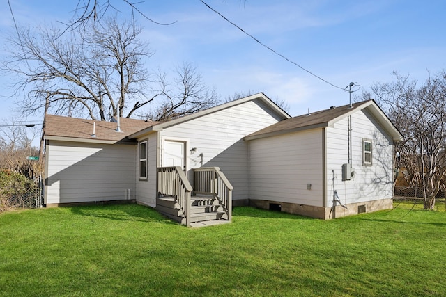 back of house featuring crawl space, fence, and a lawn